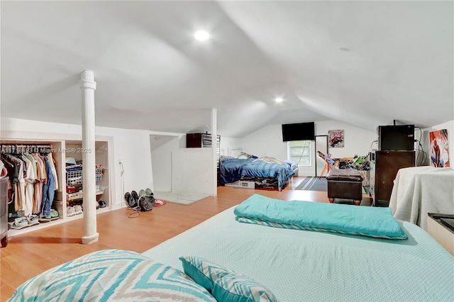 bedroom featuring a closet, vaulted ceiling, and light wood-type flooring