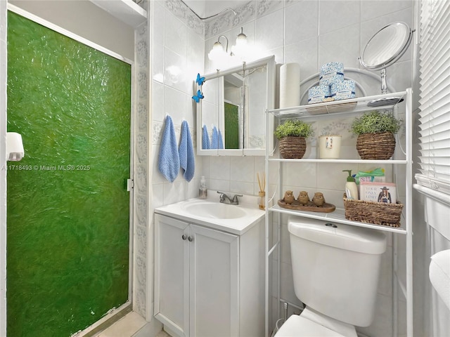 bathroom featuring tasteful backsplash, vanity, tile walls, and toilet