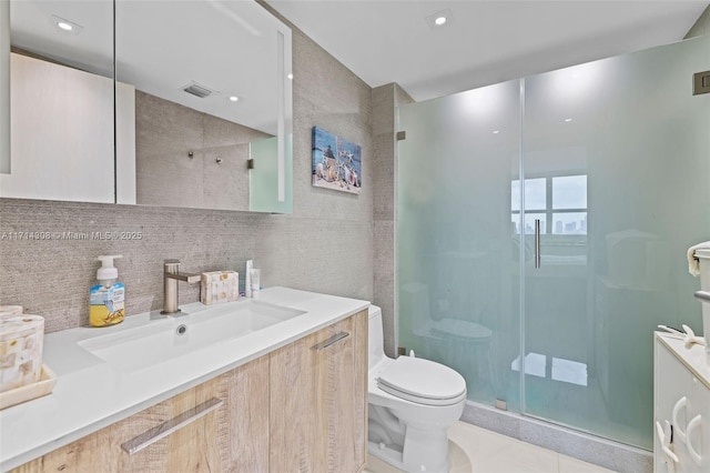 bathroom with tile patterned flooring, backsplash, an enclosed shower, toilet, and vanity