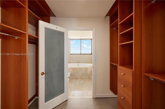 walk in closet featuring light tile patterned flooring