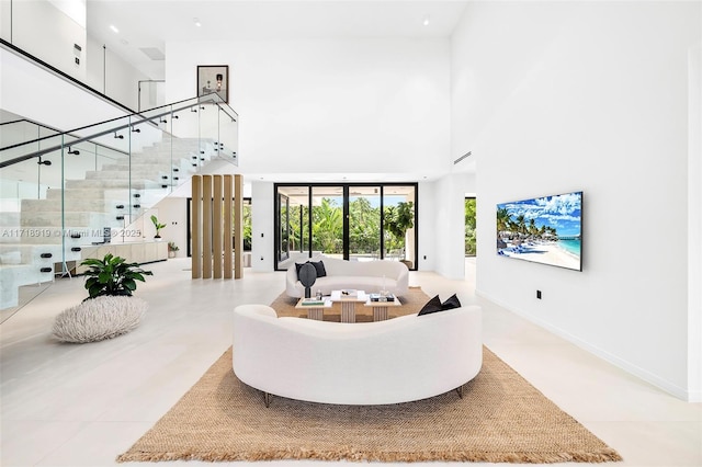 living room with a towering ceiling and light tile patterned floors