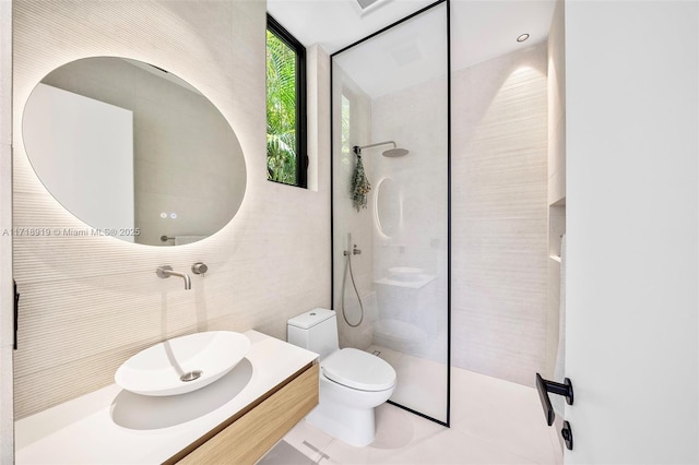 bathroom featuring vanity, floor to ceiling windows, tile patterned flooring, toilet, and tiled shower