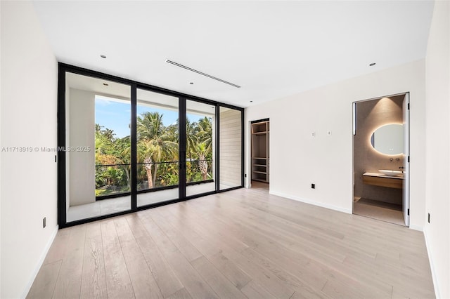 unfurnished room featuring light hardwood / wood-style floors and floor to ceiling windows