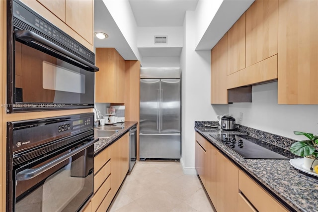 kitchen with black appliances, light brown cabinets, sink, and dark stone counters