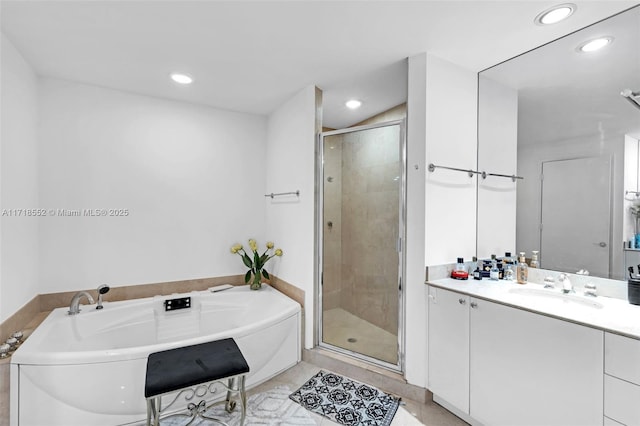 bathroom featuring tile patterned flooring, shower with separate bathtub, and vanity