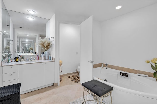 bathroom featuring tile patterned floors, vanity, toilet, and a bathing tub