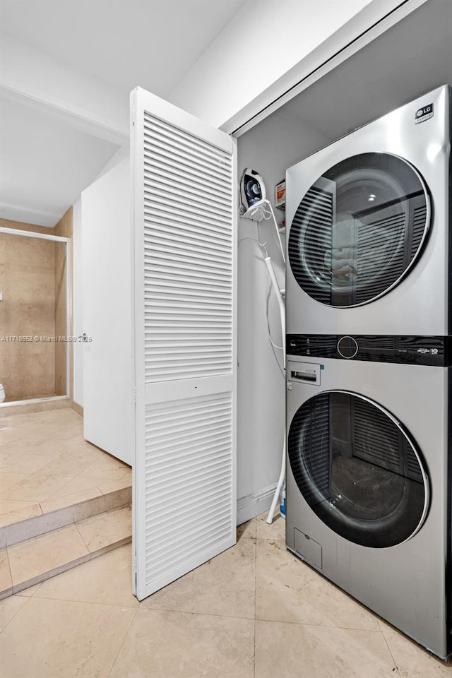 laundry room with light tile patterned flooring and stacked washing maching and dryer