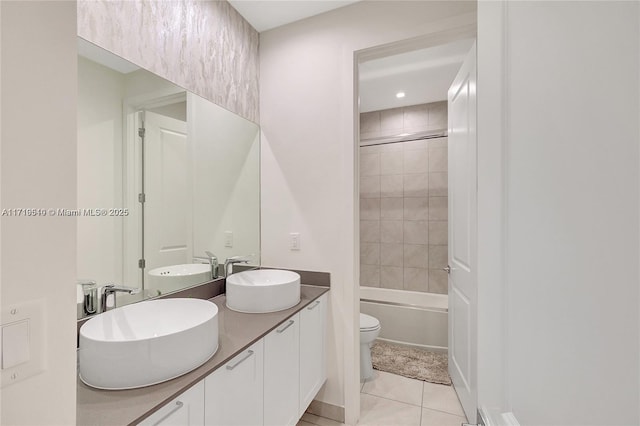 full bathroom featuring tiled shower / bath, tile patterned flooring, vanity, and toilet