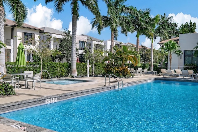 view of pool featuring a community hot tub and a patio