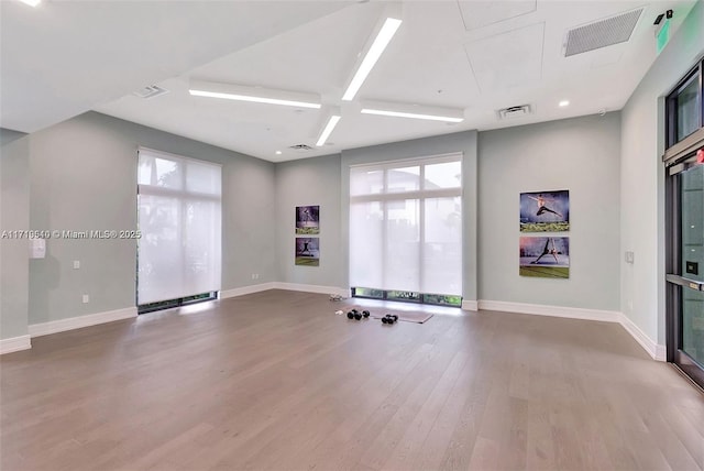 empty room with beam ceiling, wood-type flooring, and coffered ceiling