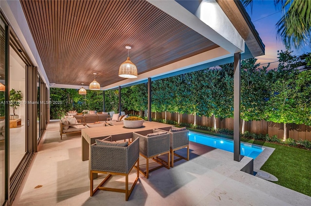 patio terrace at dusk featuring an outdoor living space and a fenced in pool