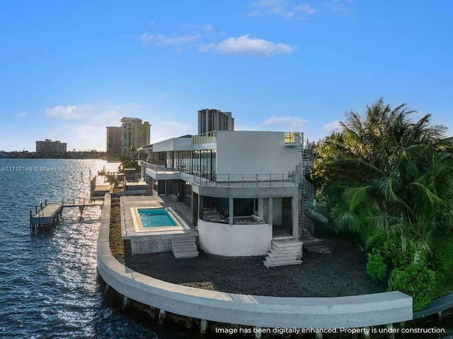 rear view of property with a water view and a hot tub