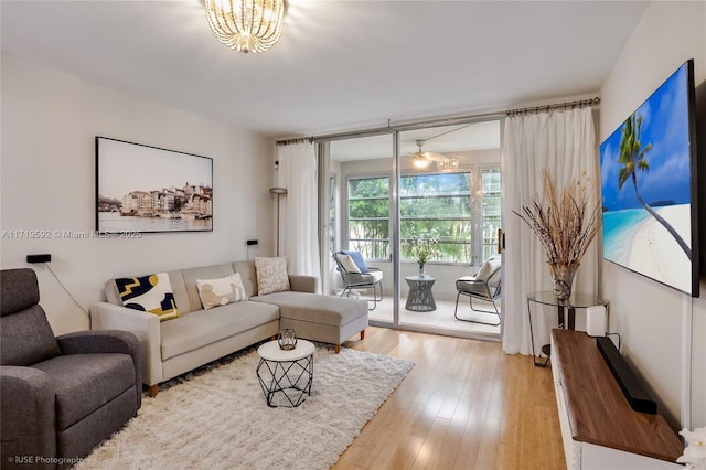 living room with an inviting chandelier and light hardwood / wood-style flooring