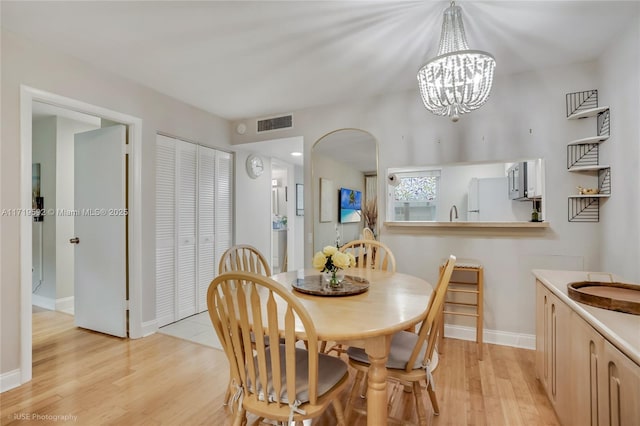 dining room featuring light hardwood / wood-style floors and a notable chandelier