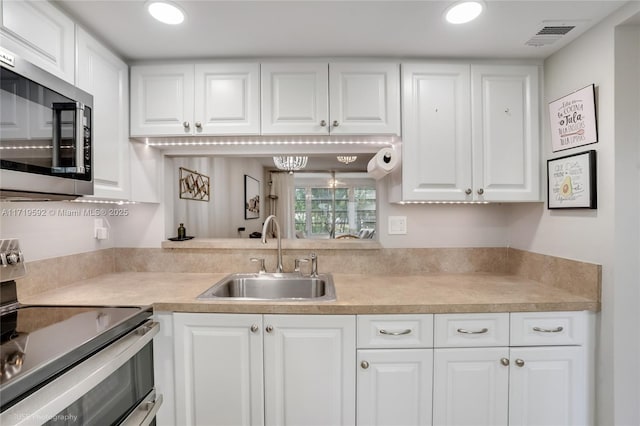 kitchen featuring sink, white cabinets, and appliances with stainless steel finishes