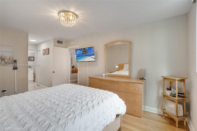 bedroom featuring a notable chandelier and light hardwood / wood-style flooring