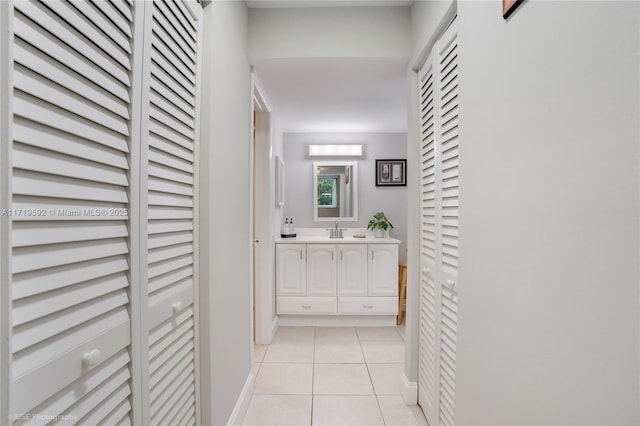 hallway featuring sink and light tile patterned flooring