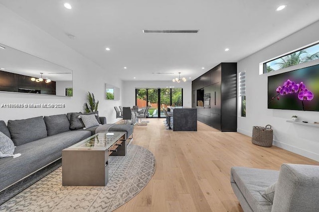 living room featuring light hardwood / wood-style flooring and a chandelier