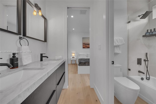 full bathroom with vanity, hardwood / wood-style flooring, toilet, and tub / shower combination