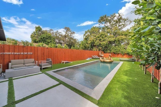 view of pool with outdoor lounge area, a patio area, and a yard