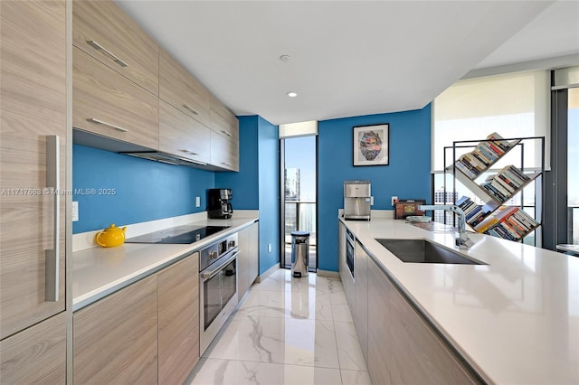 kitchen with floor to ceiling windows, stainless steel oven, light brown cabinets, sink, and black electric cooktop