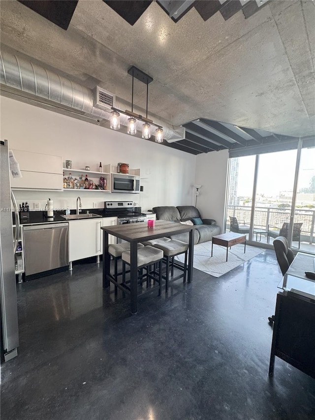 dining space featuring a wall of windows and sink