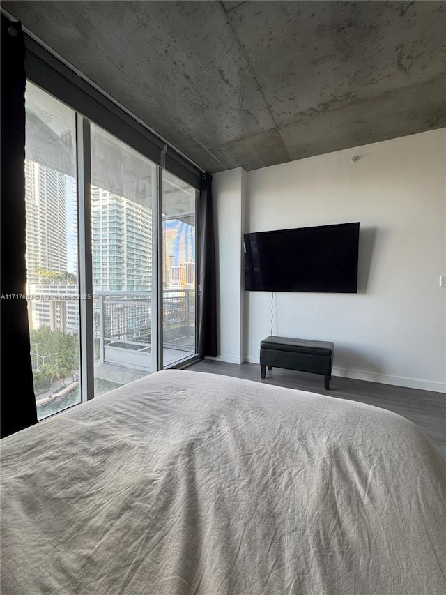 bedroom featuring hardwood / wood-style flooring, expansive windows, and access to exterior