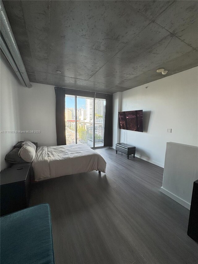 unfurnished bedroom with a wall of windows and hardwood / wood-style floors