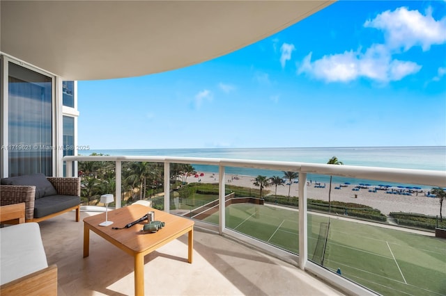 balcony with a beach view and a water view