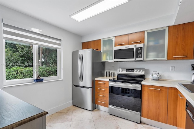 kitchen with light tile patterned floors, stainless steel appliances, and sink