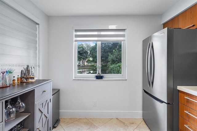 kitchen featuring light tile patterned flooring and stainless steel refrigerator