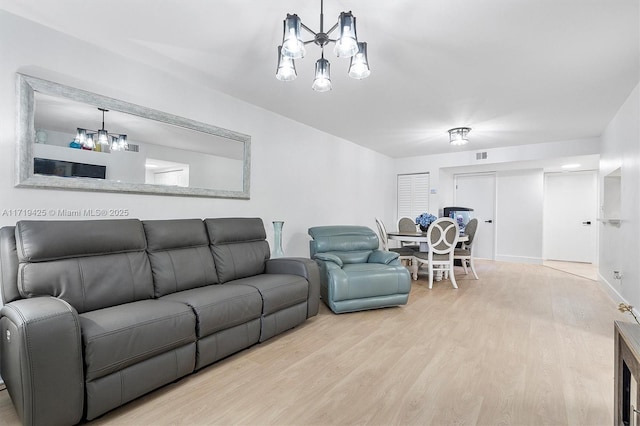 living room featuring light hardwood / wood-style floors and an inviting chandelier