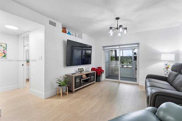 living room featuring light hardwood / wood-style floors and a notable chandelier