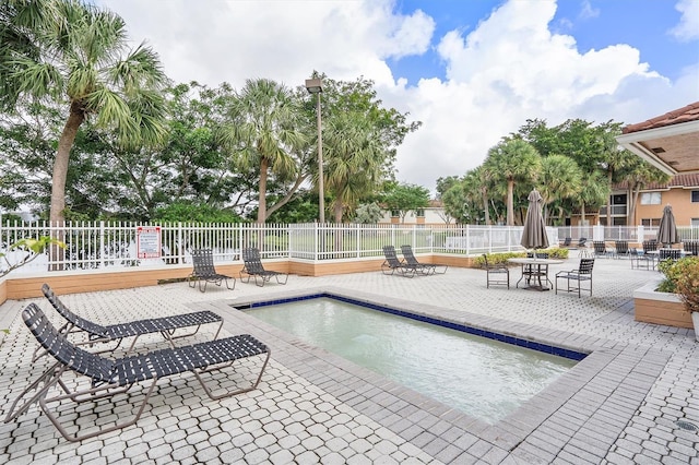 view of pool with a patio and a hot tub