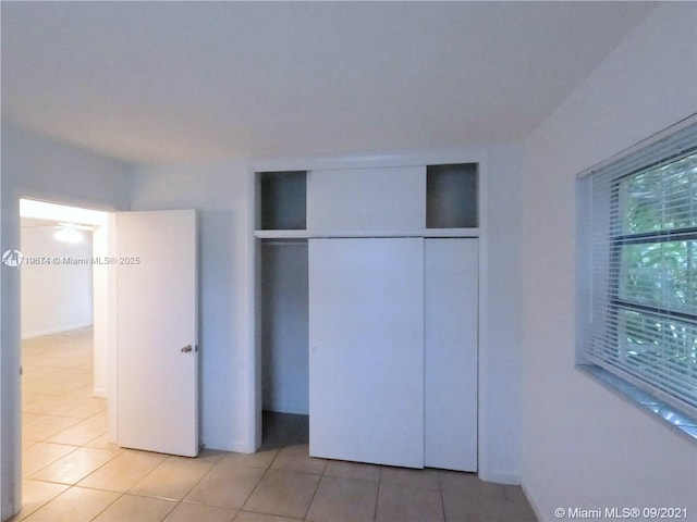 unfurnished bedroom with light tile patterned floors and a closet