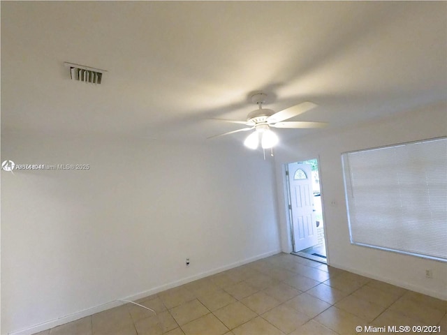 tiled empty room featuring ceiling fan