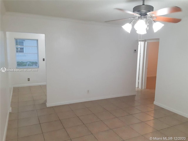 spare room featuring ceiling fan, light tile patterned floors, and crown molding