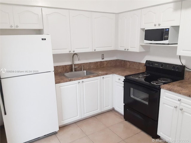 kitchen with light tile patterned floors, sink, white cabinets, and white appliances