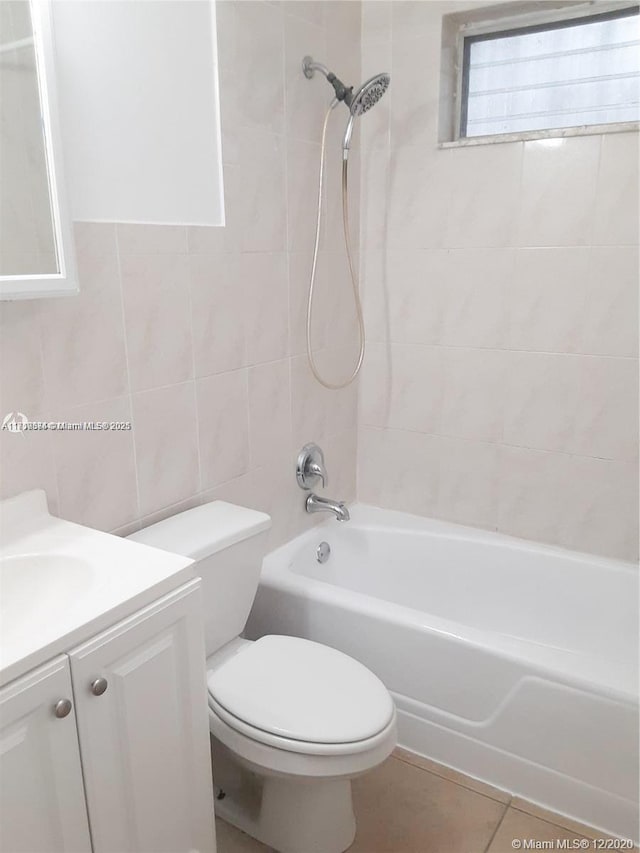 full bathroom with toilet, tile patterned floors, tiled shower / bath, and vanity