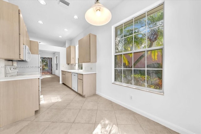 kitchen featuring sink, hanging light fixtures, white appliances, light brown cabinetry, and light tile patterned floors