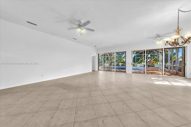 unfurnished room featuring ceiling fan with notable chandelier, light tile patterned floors, and a textured ceiling