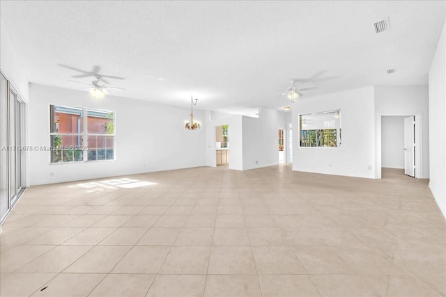 unfurnished living room with ceiling fan with notable chandelier, light tile patterned floors, and a textured ceiling