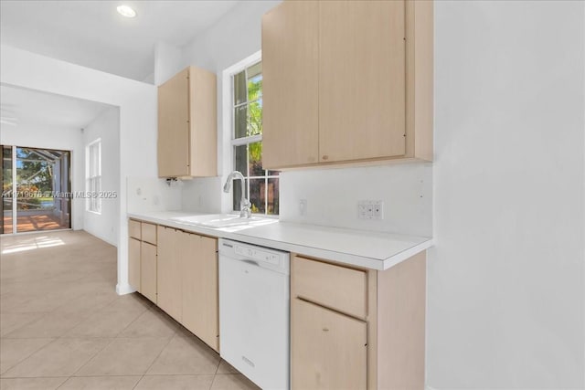 kitchen with light brown cabinetry, sink, white dishwasher, and light tile patterned flooring