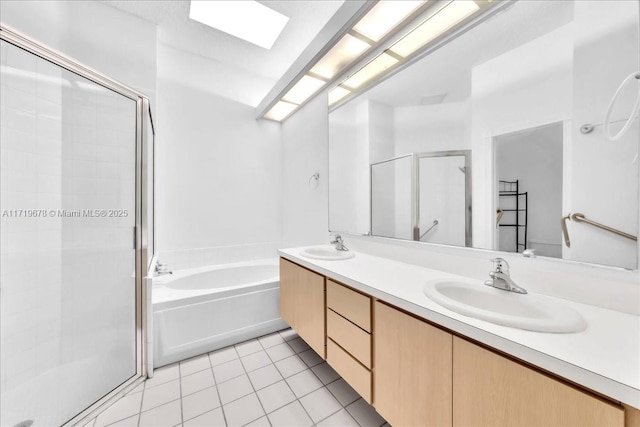 bathroom with plus walk in shower, vanity, tile patterned flooring, and a skylight