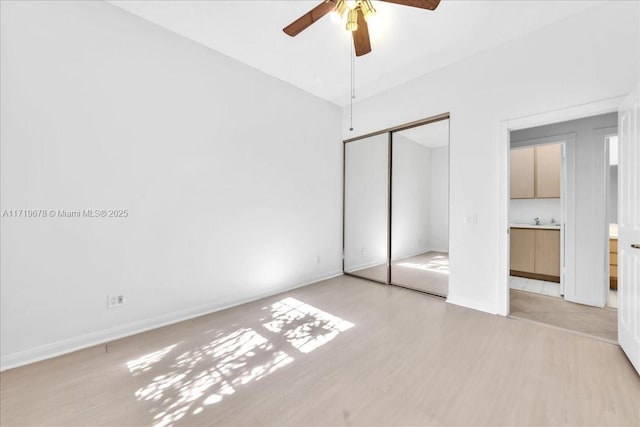 unfurnished bedroom with ceiling fan, light hardwood / wood-style floors, sink, and a closet