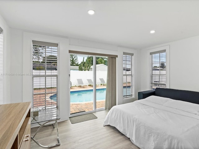 bedroom featuring light hardwood / wood-style floors, multiple windows, and access to outside