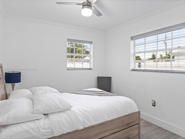 bedroom with crown molding, ceiling fan, and hardwood / wood-style flooring