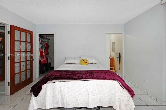 bedroom featuring a textured ceiling, a closet, and light tile patterned flooring