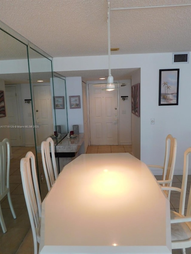 tiled dining space with a textured ceiling