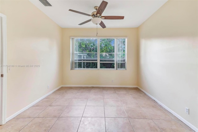 empty room with ceiling fan and light tile patterned floors